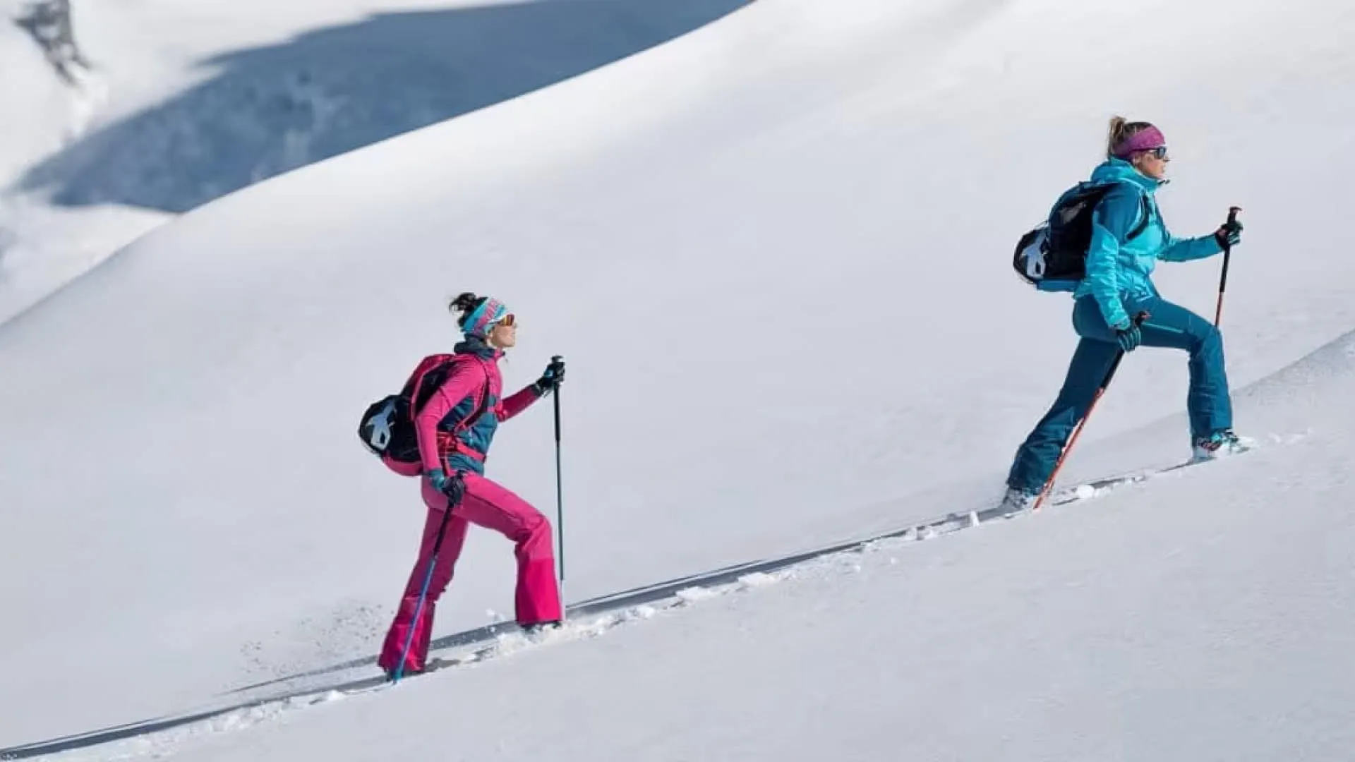 Three skiers ascending a snowy slope